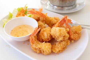 Golden brown deep-fried breaded shrimps or Tempura served with sweet plum sauce. Crispy appetizer for family meal.
