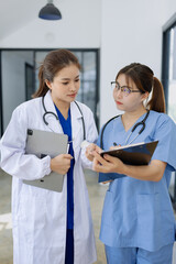 Two asian female doctor with clipboard in modern clinic, Doctor woman and medical coat working in...