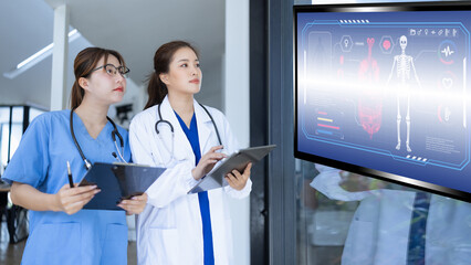 Two asian female doctor with clipboard in modern clinic, Doctor woman working with human anatomy virtual interface icons in hospital.