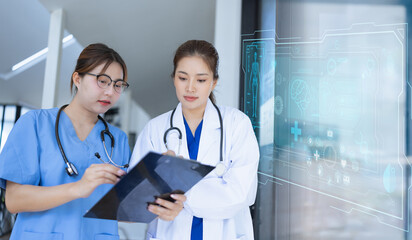 Two asian female doctor with clipboard in modern clinic, Doctor woman working with human anatomy virtual interface icons in hospital.