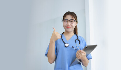 Doctor woman using digital tablet standing in clinic look at camera, Doctor woman wearing glasses and medical coat working in hospital, Healthcare professional service at modern center. 