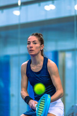 Close-up of a padel player focused on following the ball to deliver a powerful shot.
