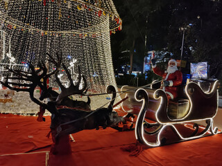 Jaipur, India 24 December 2025: Picture of Christmas decoration in a mall in Jaipur on Christmas eve shot against dark background. Santa Claus rides on a reindeer
