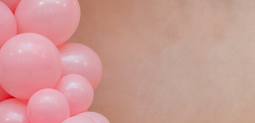 Pastel balloon background with soft pink balloons on beige wall. Minimal festive decoration with copy space, suitable for birthday, baby shower, wedding or celebration design.
