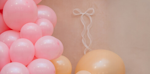 Soft pastel balloon decoration with pink and peach balloons on beige background. Delicate festive scene with copy space, suitable for baby shower, birthday or gentle celebration design.