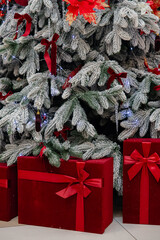 Decorated Christmas tree with red ornaments and gift boxes underneath. Festive winter holiday scene with frosted branches, perfect for Christmas, New Year, holiday greeting or seasonal design.