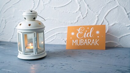 Eid mubarak celebration with lantern and greeting card on blue table