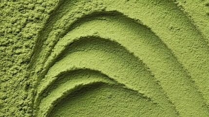Delicate matcha powder, featuring subtle green ripple patterns and smooth swirls, highlighting the natural vibrant color of the green tea powder and its fine, powdery texture.