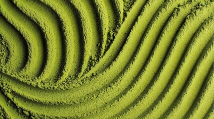 Delicate matcha powder, featuring subtle green ripple patterns and smooth swirls, highlighting the natural vibrant color of the green tea powder and its fine, powdery texture.
