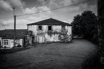 Traditional rural stone house with wooden gallery and slate roof