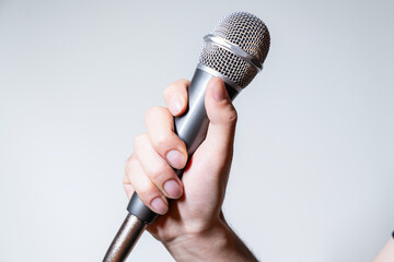 hand holding microphone against a white background