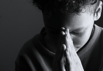 little boy praying to God with hands together with people stock image stock photo 