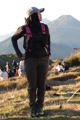 Female Hiker Standing on Mountain with Backpack During Sunrise