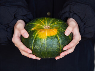 冬の屋外で子供の両手で持つ南瓜の様子