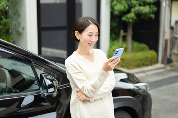 スマホを持つ女性　車　マイカー