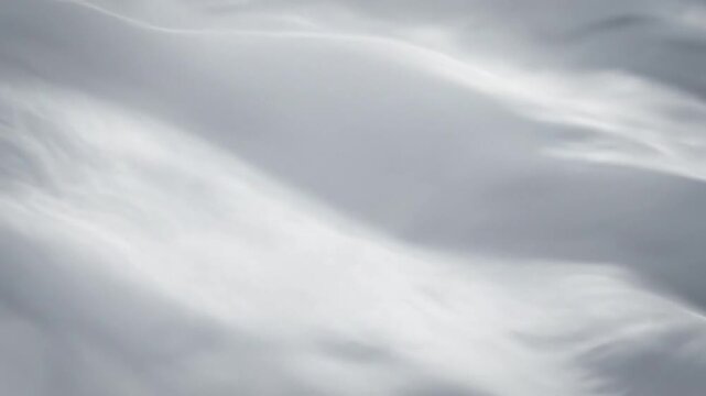 Flowing white fabric with subtle shadows in gentle, soft motion, creating an elegant backdrop.