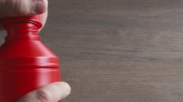 Closing a household chemical container tightly with child proof lid on a table in a safe location