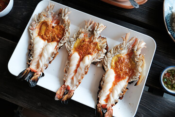 Grilled giant prawn and cutting half shrimp served on a white plate famous in Thai seafood.