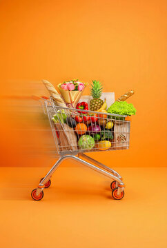 Fast-Moving Shopping Cart Filled With Fresh Groceries on Orange Background
