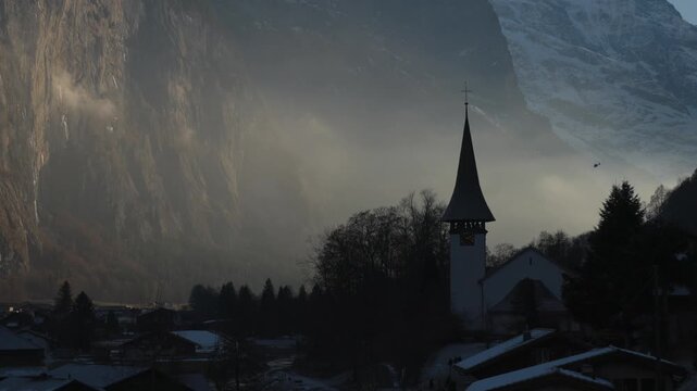 Dramatic morning light over Lauterbrunnen village and church, Swiss Alps.