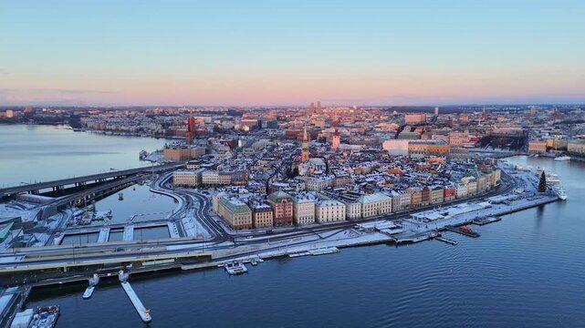 Amazing sunrise over the old town of Stockholm, with snow on the buildings, forward panoramic motion