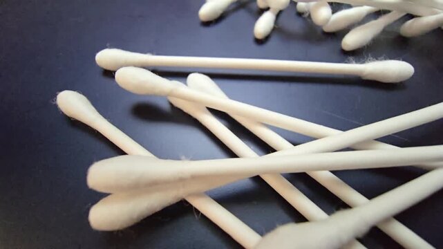 Slow motion falling of cotton swabs on a neutral background