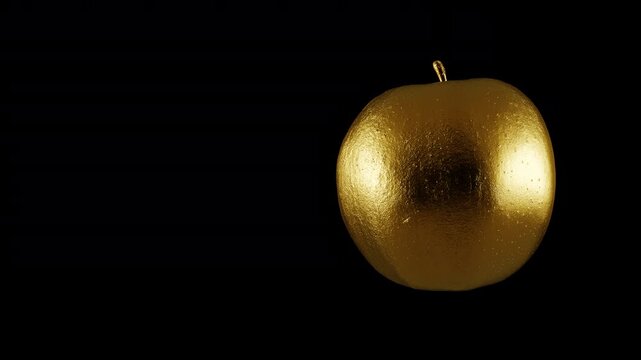 Luxury golden apple rotating loop with copy space on left, premium metallic fruit 3D rendering for award or business background.