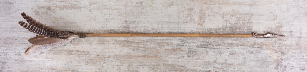 medieval arrow with feathers on a wooden background