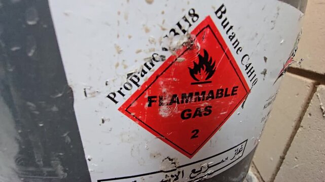Close-up of flammable gas warning label on a propane and butane cylinder