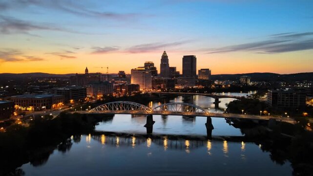 Breathtaking aerial view of Hartford Connecticut cityscape at dusk with bridges and calm river reflection