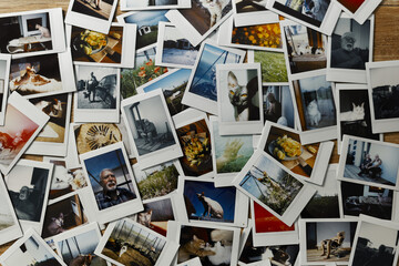 Collection of polaroid photos showing various subjects and activities spread across a wooden surface in a casual setup