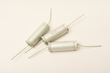 Old capacitors in paper packaging. Aluminum capacitors on a white background. Electronic components.