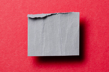One single gray torn ripped wrinkled crumpled blank paper note with drop shadow, folded edge and copy space for text on background
