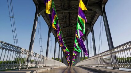 Vibrant mardi gras flags adorning bridge on a clear day capturing the essence of new orleans carnival. concept of festive decor, cultural celebration, joyful atmosphere