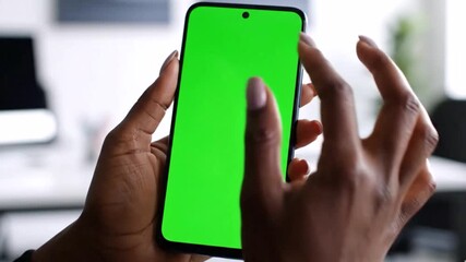 Close up of dark skinned hands interacting with a modern smartphone featuring a vibrant green screen ideal for custom content insertion or app demonstration in a professional setting - Powered by Adobe