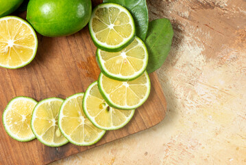 Fresh Sliced Green Limes Arranged on Wooden Cutting Board with Rustic Background