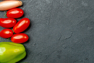 Fresh Red Cherry Tomatoes and Green Bell Pepper on Dark Textured Background with Copy Space