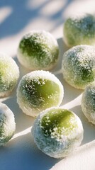 Glossy green mochi balls coated in shredded coconut on a sunlit white surface, macro foreground with soft shadows and blurred background, concept of asian dessert branding