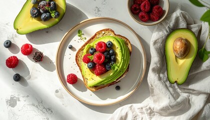 Avocado Toast With Raspberries And Blueberries On White Plate With Half Avocado And Bowl Of Raspberries For Healthy Eating Concepts