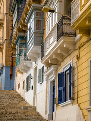 Valletta old town narrow street with traditional Maltese balconies and limestone facades