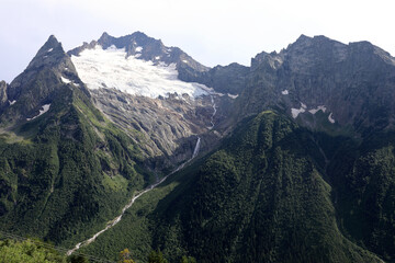 Majestic mountain landscape with active glacier and waterfall