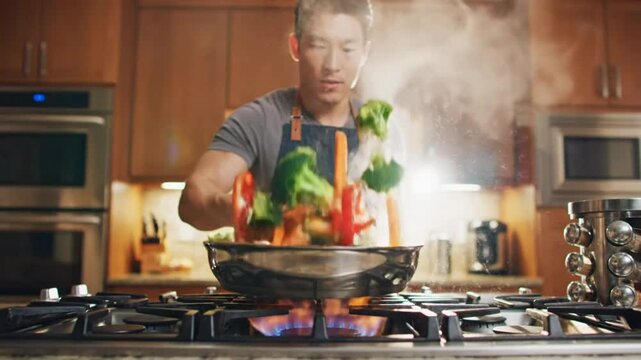 Chef tossing colorful vegetables in a pan over a gas stove flame in a modern kitchen, cooking show concept
