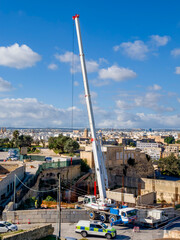 Construction crane at a construction site with Valletta skyline