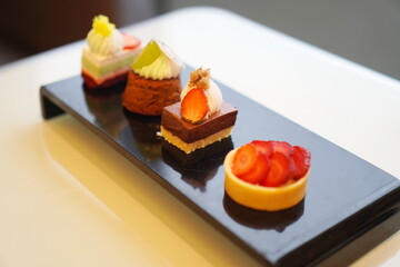 Food, hospitality and room service, Petit Fours on black coasters with an angled view