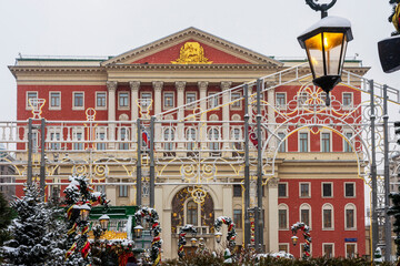 Moscow, Russia - 30 December 2025: Historic building behind illuminated winter festival arches and Christmas trees,  government building, city hall.