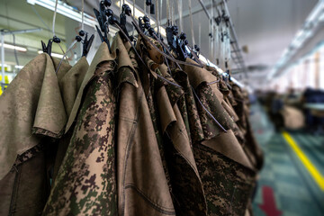 Military pixel camouflage jackets on factory hangers
