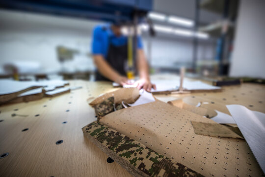 Workplace of tailor cutting camouflage fabric for uniform