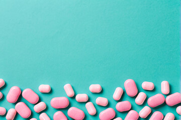 Pink Pills Scattered Randomly on Turquoise Background in Minimalist Style