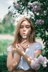 A fascinating portrait of a woman surrounded by beautiful purple lilacs under the bright sun