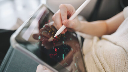 Person using a tablet with stylus to analyze financial data